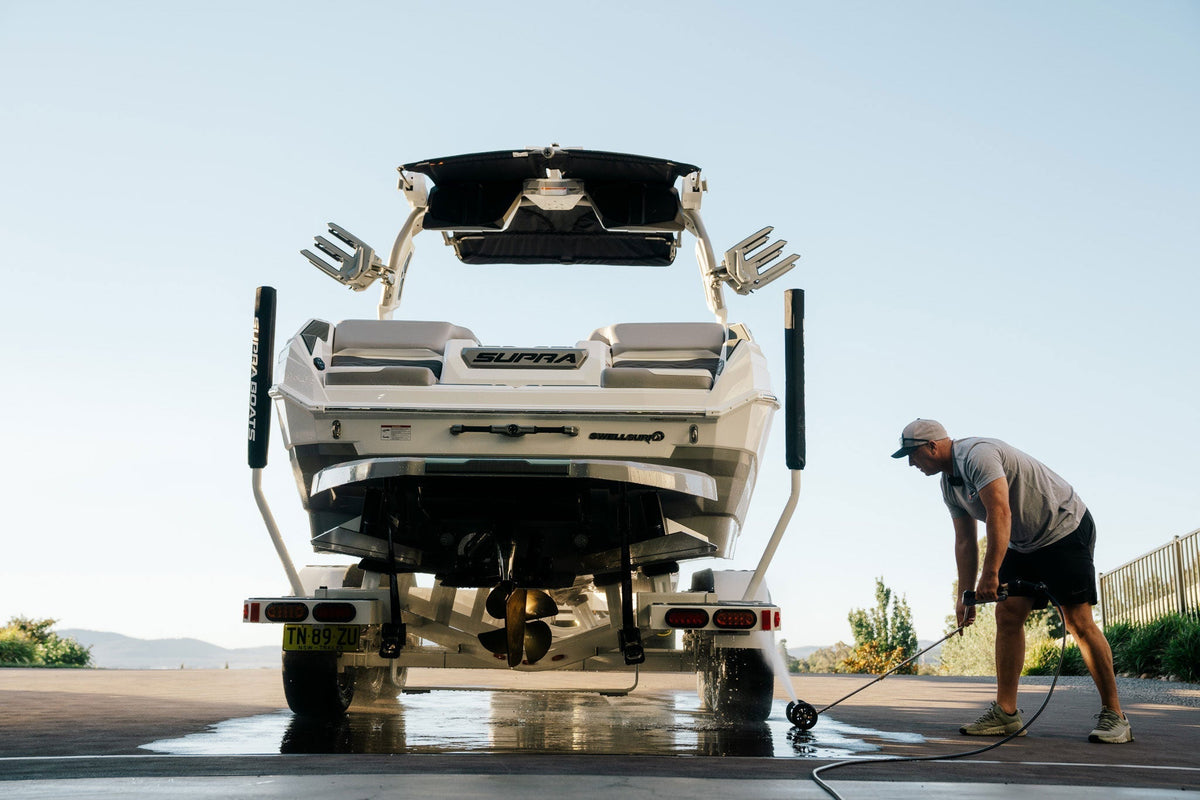 Boat on a trailer being rinsed with a pressure washer
