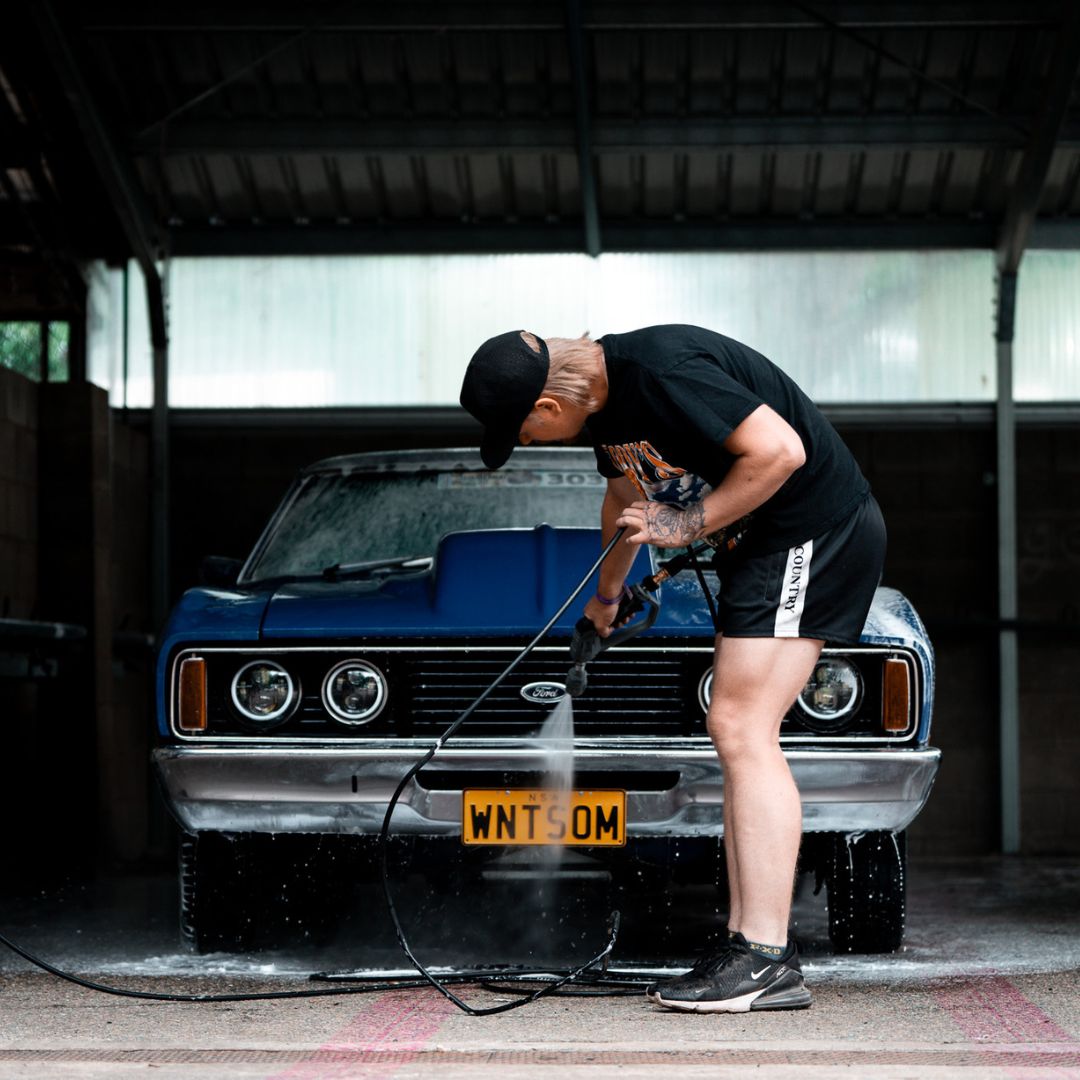 Car being washed with pressure washer accessories